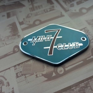 Puede incluir: Una insignia de color azul verdoso en forma de diamante con un borde plateado y una inscripción en blanco que dice "MINI 7 CLUB". El número 7 está en marrón y es más grande que el resto del texto. La insignia está sobre un fondo de fotos antiguas de Mini Coopers.