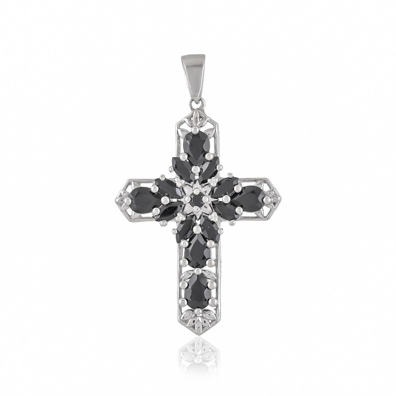 May include: A silver cross pendant with black gemstone accents. The cross is adorned with a floral design and features a bail for attaching to a chain.