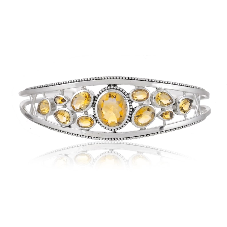 Puede incluir: Un brazalete de plata con un dise&ntilde;o delicado que presenta m&uacute;ltiples piedras de citrino ovaladas.
