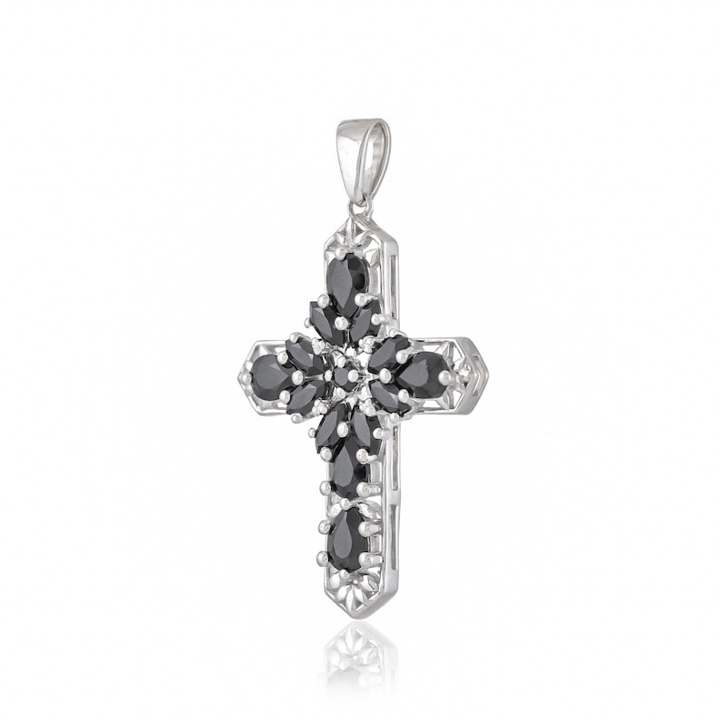 May include: Silver cross pendant with black gemstone accents. The cross is detailed with intricate designs and features a floral pattern.