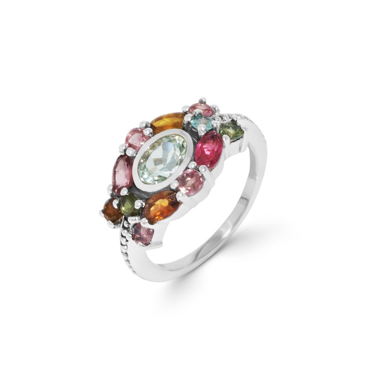 K&ouml;nnte beinhalten: Ein silberner Ring mit einem Cluster aus bunten Edelsteinen, darunter Aquamarin, Rosa, Gr&uuml;n und Orange.