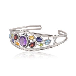 Puede incluir: Pulsera de plata con un dise&ntilde;o delicado que presenta una variedad de piedras preciosas de colores, incluyendo amatista, granate, peridoto y topacio.
