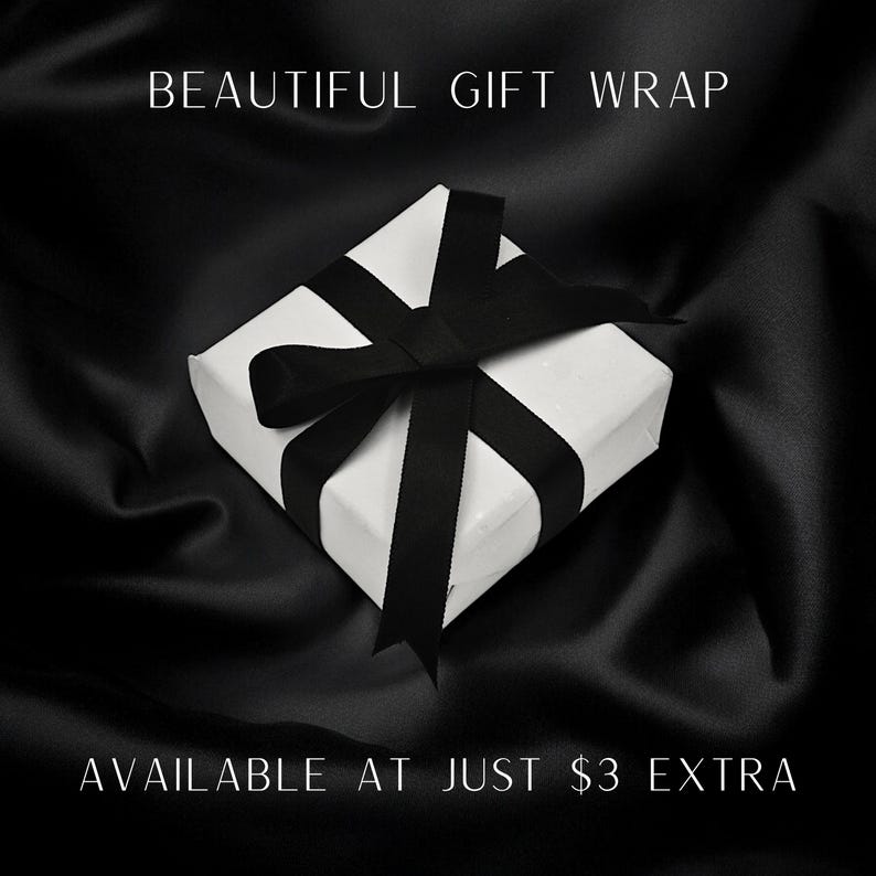 May include: A white gift box with a black ribbon tied in a bow. The text "BEAUTIFUL GIFT WRAP" is at the top of the image and the text "AVAILABLE AT JUST $3 EXTRA" is at the bottom of the image.