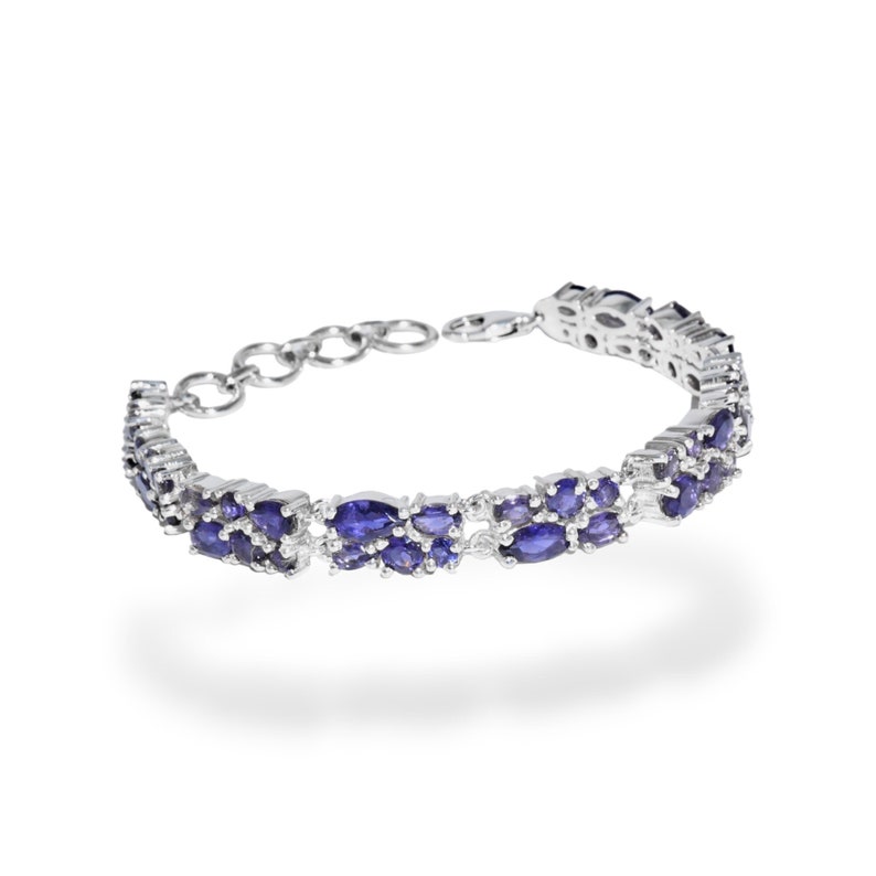 May include: A silver bracelet featuring two rows of oval-shaped, deep blue gemstones. The bracelet has a delicate chain and clasp closure. The gemstones are set closely together, creating a continuous band of color. The jewelry is displayed against a white background.