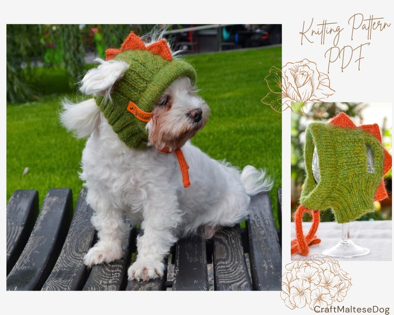 May include: A white dog wearing a green and orange knitted dinosaur hat. The hat has orange spikes and a small orange strap. The image also includes a smaller image of the hat on a glass and the text "Knitting Pattern PDF".