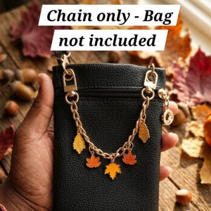 May include: A gold-toned metal chain strap featuring multiple colorful enamel leaf charms in shades of yellow and orange, attached to a black textured pouch. The text "Chain only - Bag not included" is displayed across the top of the image.