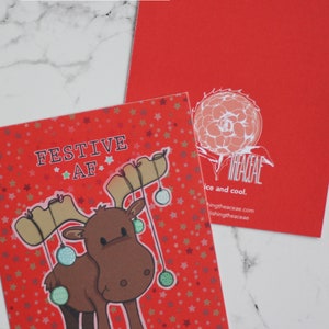 Grafischer niedlicher Elch mit Weihnachtsverzierungen, die von seinem Geweih hängen Karte - Umschlag - innen blanko - Feiertag - “Festliche AF”