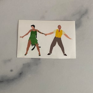 May include: A sticker featuring a couple dancing. The woman is wearing a green dress and the man is wearing a yellow vest and brown pants.