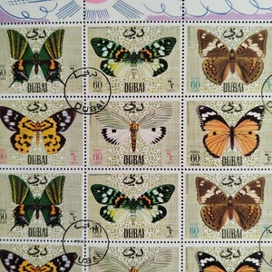 May include: Sheet of postage stamps featuring various butterfly illustrations. Each stamp includes the word "DUBAI" and the number "60". The stamps showcase butterflies in shades of green, brown, yellow, orange, and white.