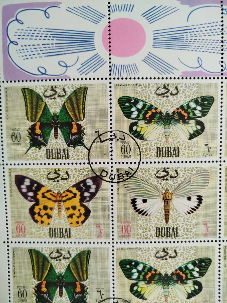 May include: A sheet of postage stamps from Dubai featuring colorful butterfly illustrations. Each stamp displays a different butterfly species with intricate wing patterns, set against a patterned background. The stamps are marked with the value of 60 Dirham.