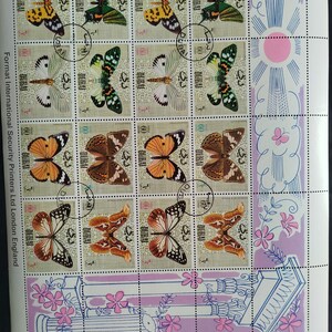 May include: Sheet of postage stamps featuring various butterfly illustrations. The stamps showcase butterflies in shades of yellow, green, orange, brown, and white. The stamps are marked with the word "DUBAI" and the number "60".