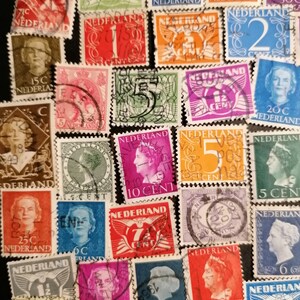 May include: A collection of vintage Dutch postage stamps featuring various designs and denominations. The stamps are in different colors, including red, blue, green, and yellow. Some stamps feature portraits of people, while others feature images of birds, flowers, and other designs. The stamps are in good condition and would be a great addition to any stamp collection.