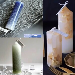 May include: A collection of handmade pillar candles in various colors and designs. One candle is blue with a crackle pattern, another is green, and others are white with gold leaf accents. Each candle has a tag that says "HANDMADE" or "TRANQUIL".