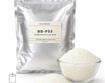 May include: A silver bag of BB-P55 paraffin pillar wax, with a clear glass bowl and a small pile of white wax beads. The label reads "BLOOMBAY" and "PARAFFIN PILLAR WAX." The net weight is 1 lb. A candle icon with text "For Pillar Candles & Molds" is in the lower left.