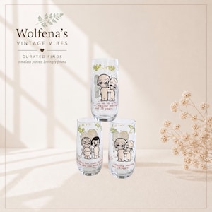 May include: Three clear vintage glasses with a cartoon couple design. The glasses have green floral accents and text that reads "making marriage last 75 years." The glasses are from Wolfena's Vintage Vibes.