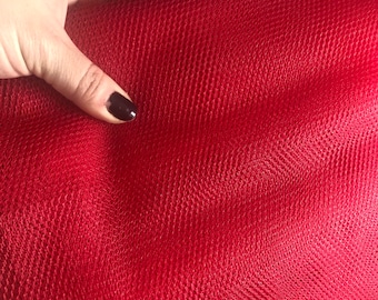 Può includere: Tessuto di tulle rosso con una trama a rete fine.