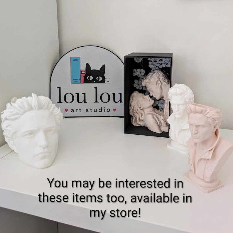 May include: Three white and pale pink wax busts of a man and a woman, including a framed relief of a couple. A sign with a black cat logo reads lou lou art studio. The text reads: You may be interested in these items too, available in my store!
