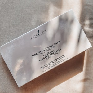 Puede incluir: Una caja rectangular blanca con el texto "Northern Lights Farm The Collection" en negro. La caja también muestra "Young Living Essential Oils" y "Nature Distilled, Life Enhanced." Contiene 4 botellas de aceite esencial, cada una de 5 ml.