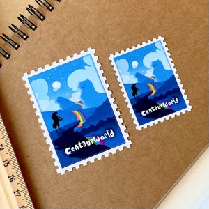 May include: Two blue and white postage stamp stickers with a rainbow and the text "Centaurworld" on each. The larger sticker has a silhouette of a centaur and a moon in the sky. The smaller sticker has a silhouette of a centaur and a rainbow.