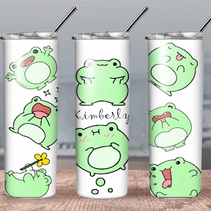 May include: A white stainless steel tumbler with a green frog design. The tumbler has a lid and a straw. The tumbler has the name "Kimberly" written on it.