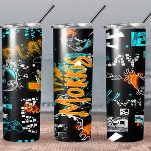 May include: Three black and white stainless steel tumblers with a gamer theme. The tumblers feature a blue and orange design with a video game controller, flames, and the word "MOKRIS".