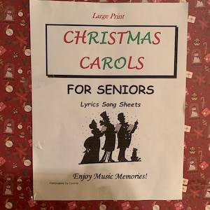 May include: A white sheet with the words "CHRISTMAS CAROLS FOR SENIORS" in large print. The text is in a black rectangle with red and green lettering. Below the text is a silhouette of carol singers and a dog. The background is a red Christmas-themed pattern.