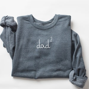 May include: A dark gray sweatshirt with the text "dad²" in white lettering.