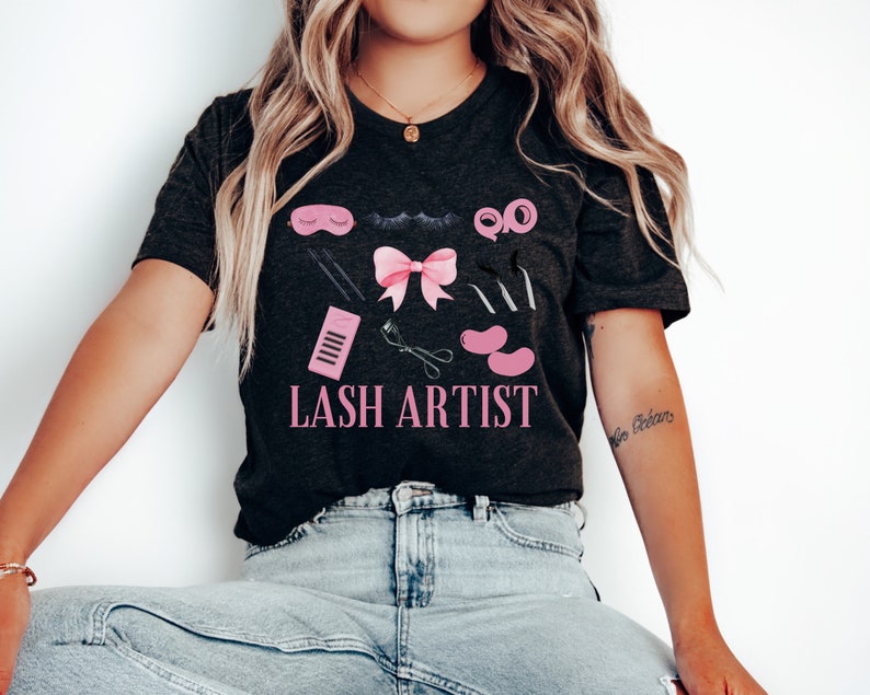 Pu&ograve; includere: Una maglietta nera con un design rosa e nero di strumenti per ciglia e il testo "LASH ARTIST".