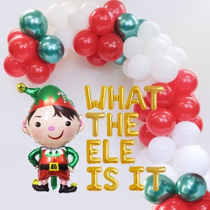 May include: A festive Christmas balloon arch with red, white, and green balloons. A large elf-shaped balloon is featured, along with gold letter balloons spelling "WHAT THE ELE IS IT".