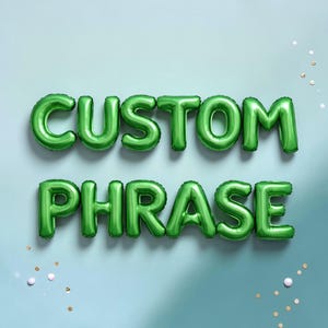 May include: Green foil balloon letters spelling "CUSTOM PHRASE" against a light blue background. The balloons are inflated and arranged in two rows. Scattered confetti adds a festive touch.