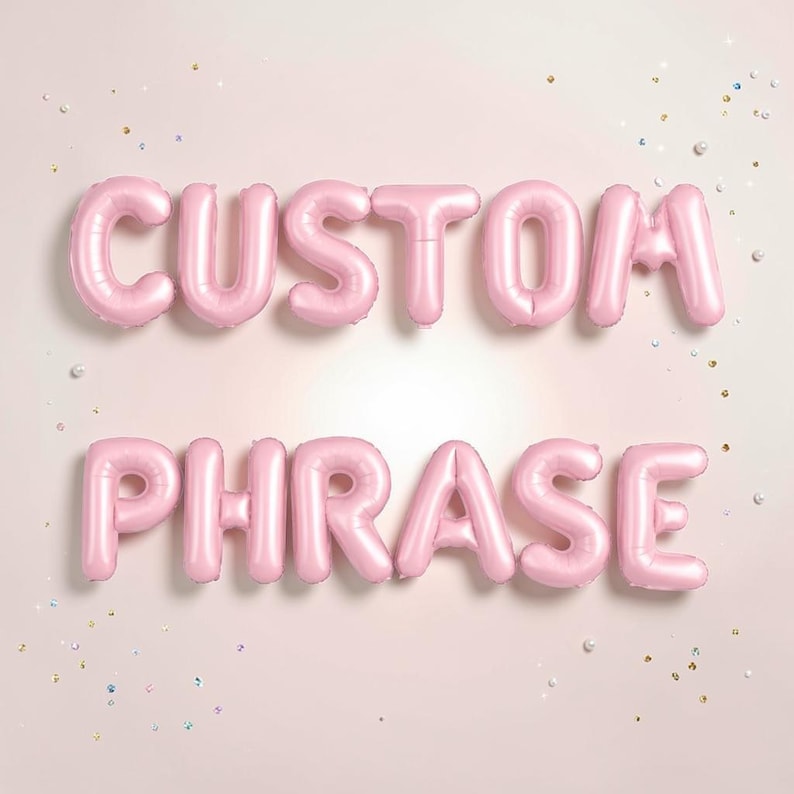 May include: Pink foil balloons spelling out "CUSTOM PHRASE" on a light pink background. The balloons are arranged in two lines, with the words clearly visible. Scattered confetti adds a festive touch to the scene.