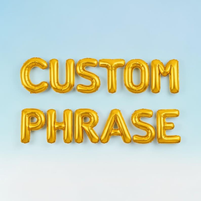 May include: Gold foil balloons spelling out "CUSTOM PHRASE" against a light blue gradient background. The balloons are inflated and have a shiny, metallic finish, perfect for a party or event.