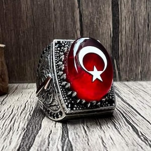 Anillo de ámbar con forma de estrella creciente y grabado de la letra Elif. Diseño único y elegante. Joyería personalizable.