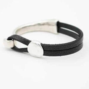 May include: A black leather bracelet with a silver-colored clasp and accents. The bracelet features two parallel leather bands and a curved silver bar. The design is minimalist and modern, suitable for everyday wear.