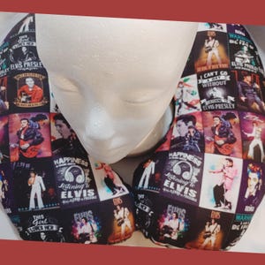 May include: A black travel neck pillow with a collage of Elvis Presley images and text. A white mannequin head is in the center. The images show Elvis in various poses, with text including "Happiness Listening to Elvis" and "Can't Go a Day Without".