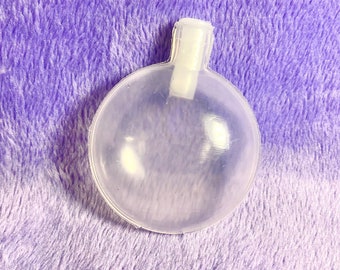 May include: A clear plastic squeaky dog toy shaped like a ball with a white plastic handle.