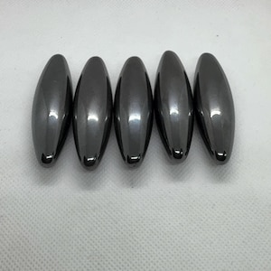May include: Five dark grey, oval-shaped magnetic fidget toys.