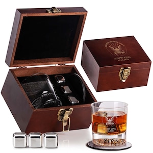 May include: A wooden whiskey gift set with a glass, whiskey stones, and a coaster. The set includes a wooden box with a clasp and a personalized inscription. The glass has a personalized inscription and is filled with whiskey and ice cubes.