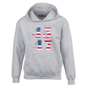 May include: A grey hooded sweatshirt with the numbers 45 and 47 printed on the front. The numbers are in a distressed style and are made up of the American flag.