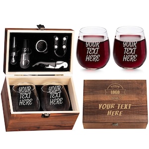 May include: A wooden wine gift set with two stemless wine glasses filled with red wine, and a wooden box containing wine accessories. The glasses and box are engraved with the text "YOUR TEXT HERE" and "YOUR LOGO HERE".