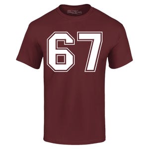 May include: A maroon t-shirt with the number "67" in white, outlined in white. The number is large and centered on the front of the shirt. The shirt has short sleeves and a crew neck. The brand name "Shop4Ever" is printed on the top.