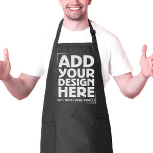 May include: A black apron with two pockets and adjustable straps. The apron has white text that says "ADD YOUR DESIGN HERE TEXT / PHOTO / IMAGE / LOGO +"