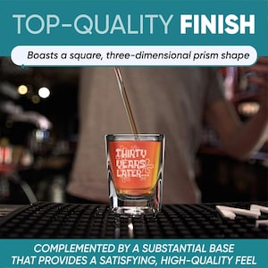 Peut inclure: Un verre &agrave; shot transparent avec le texte "THIRTY YEARS LATER" en blanc. Le verre est rempli d'un liquide orange et est pos&eacute; sur une surface noire. Le haut de l'image indique "TOP-QUALITY FINISH".