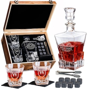May include: A personalized whiskey decanter set with a wooden box. The set includes a decanter, four glasses, whiskey stones, and tongs. The glasses and decanter feature the letter "W" and the name "WILLIAMS 2026".