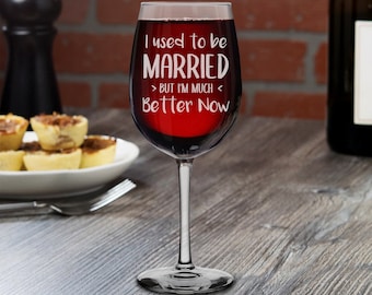 Puede incluir: Una copa de vino de vidrio transparente llena de vino tinto. La copa está grabada con el texto "Estaba casado, pero ahora estoy mucho mejor".