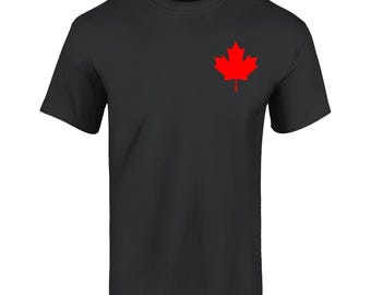 Pode incluir: Camiseta preta com uma folha de bordo canadense vermelha na frente.