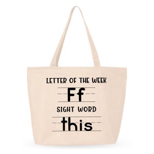 May include: A beige tote bag with black text that reads "Letter of the Week F f Sight Word this".