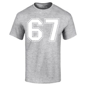 May include: A heather gray t-shirt with the number "67" printed in white. The number is in a block style with a white outline. The shirt has short sleeves and a crew neck. The brand name "Shop4Ever" is printed on the collar.