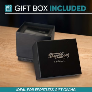 Peut inclure: Bo&icirc;te cadeau noire ouverte, avec le logo "Shop4Ever" argent&eacute;. L'int&eacute;rieur est sombre. Le texte "GIFT BOX INCLUDED" est visible en haut de l'image.