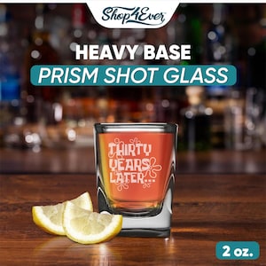 Peut inclure: Un verre &agrave; shot prismatique &agrave; base lourde et transparente avec le texte "THIRTY YEARS LATER..." en blanc. Le verre contient un liquide orange et est accompagn&eacute; de trois quartiers de citron. Le verre &agrave; shot est de 59 ml.